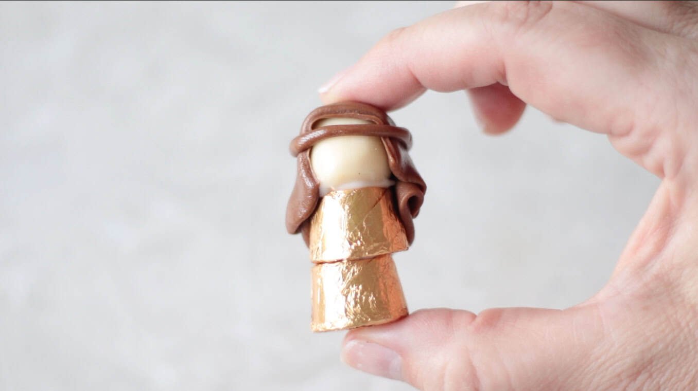 Hand holding a Joseph made out of Tootsie Rolls and Rolos.