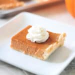 Slice of pumpkin slab pie on white plate.