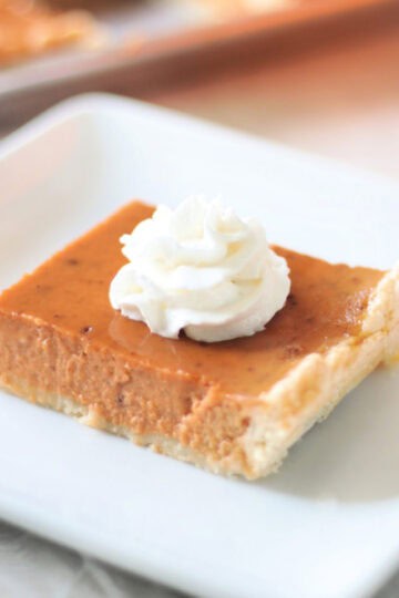 Slice of pumpkin slab pie on white plate.