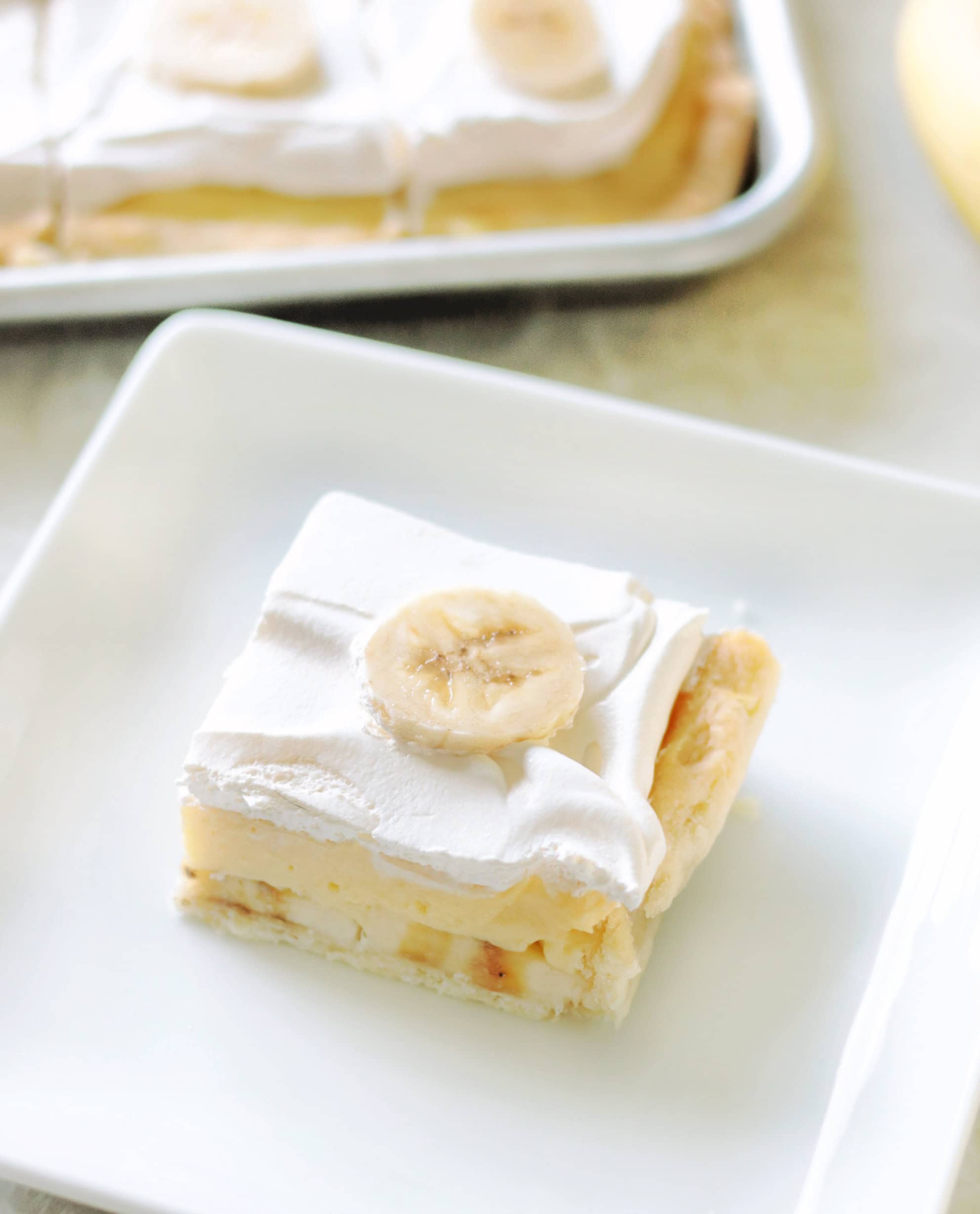 Slice of banana cream pie on a white plate.