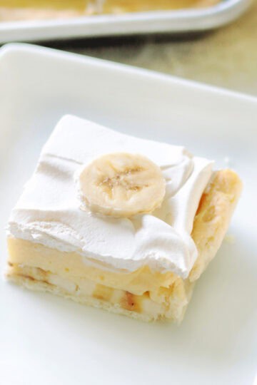 Slice of banana cream slab pie on a white plate.