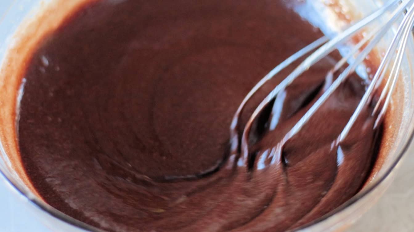 Whisk stirring bowl of melted chocolate mixture.