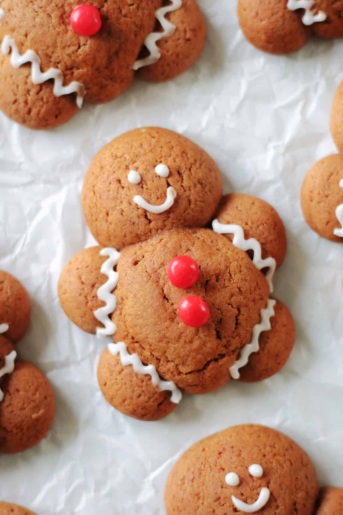 Chubby gingerbread man cookies on parchment paper.