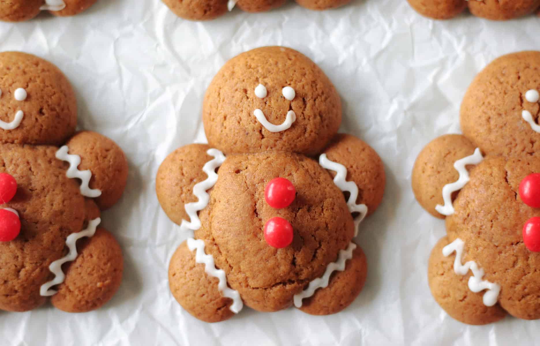Chubby gingerbread man cookies on parchment paper.