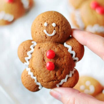 Hand holding gingerbread man cookie.