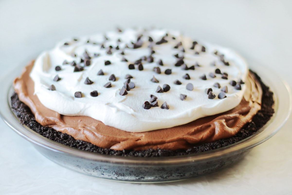 No bake French silk pie topped with whipped cream and mini chocolate chips.