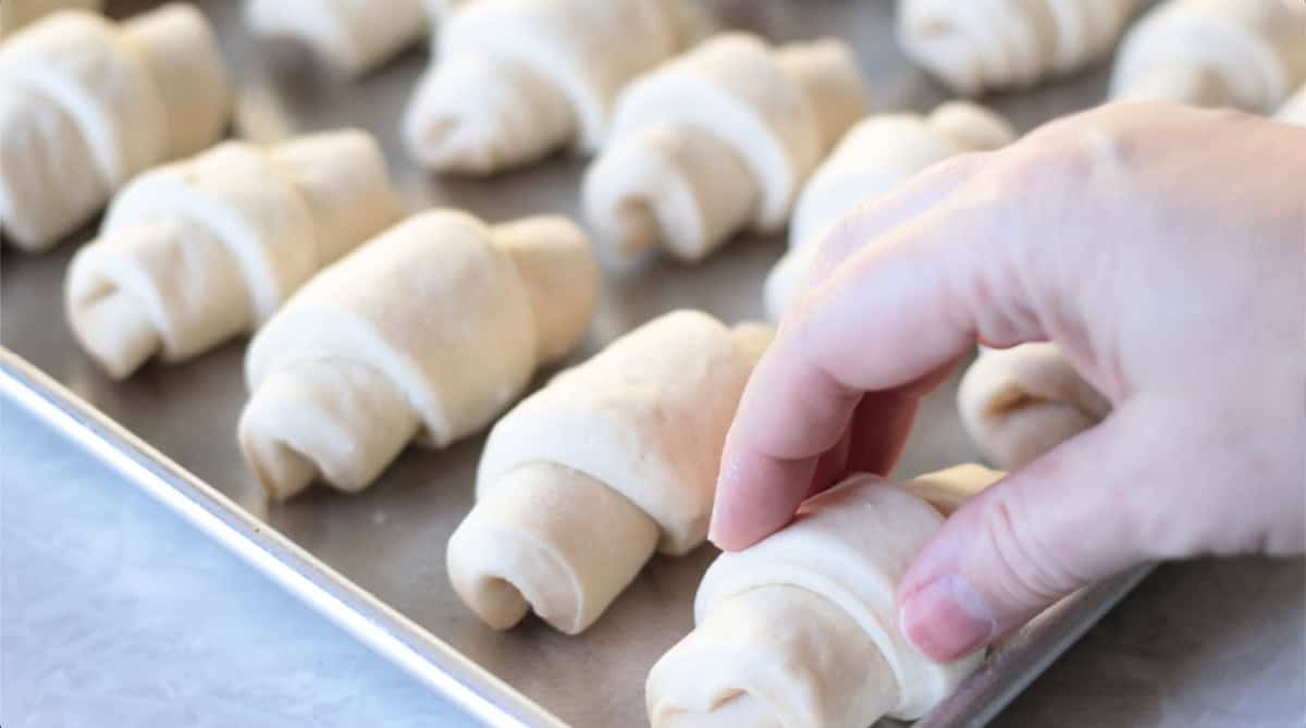 Baking sheet with unbaked crescent rolls.