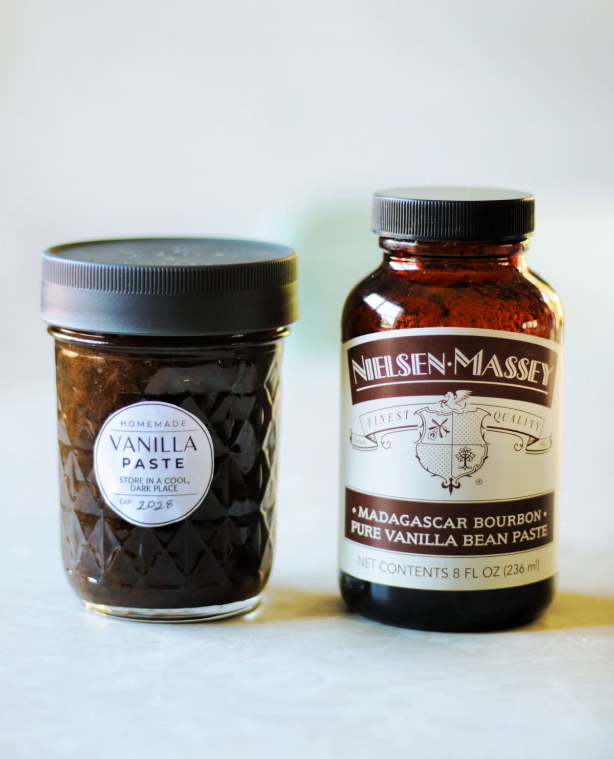 Jar of homemade vanilla paste next to jar of storebought vanilla paste.