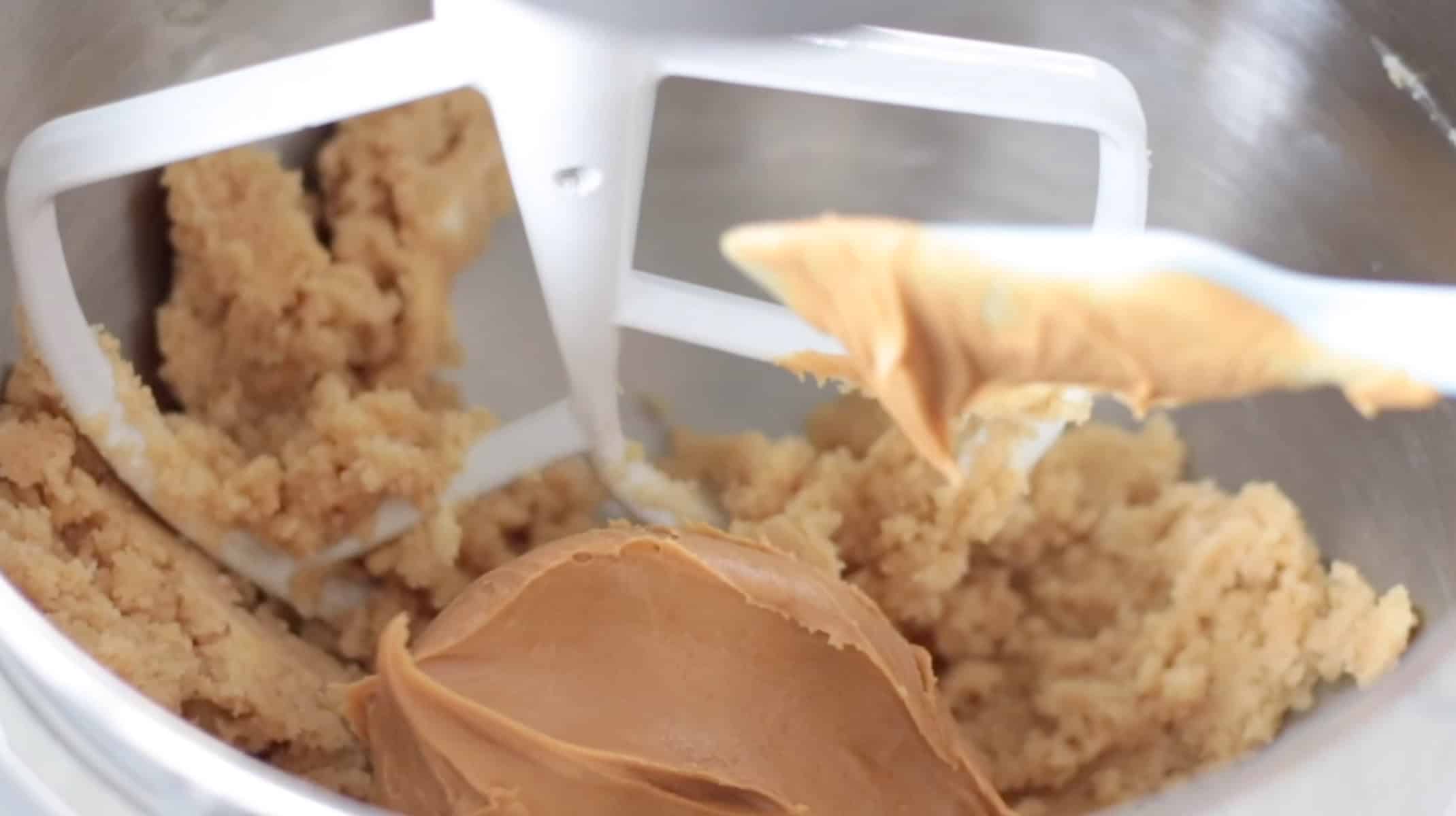 Butter, sugar and peanut butter in mixing bowl with paddle attachment.