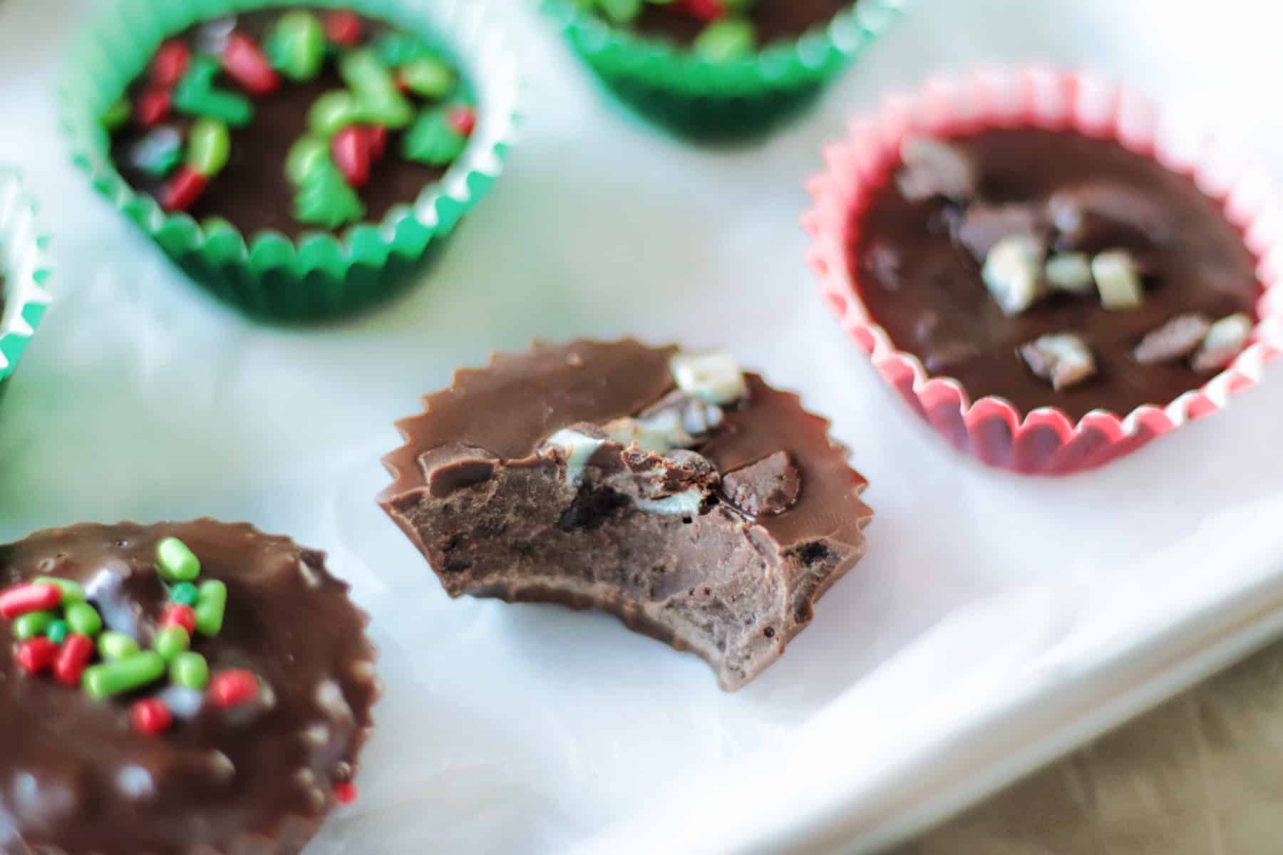 White platter with thin mint chocolates and one with a bite taken from it.