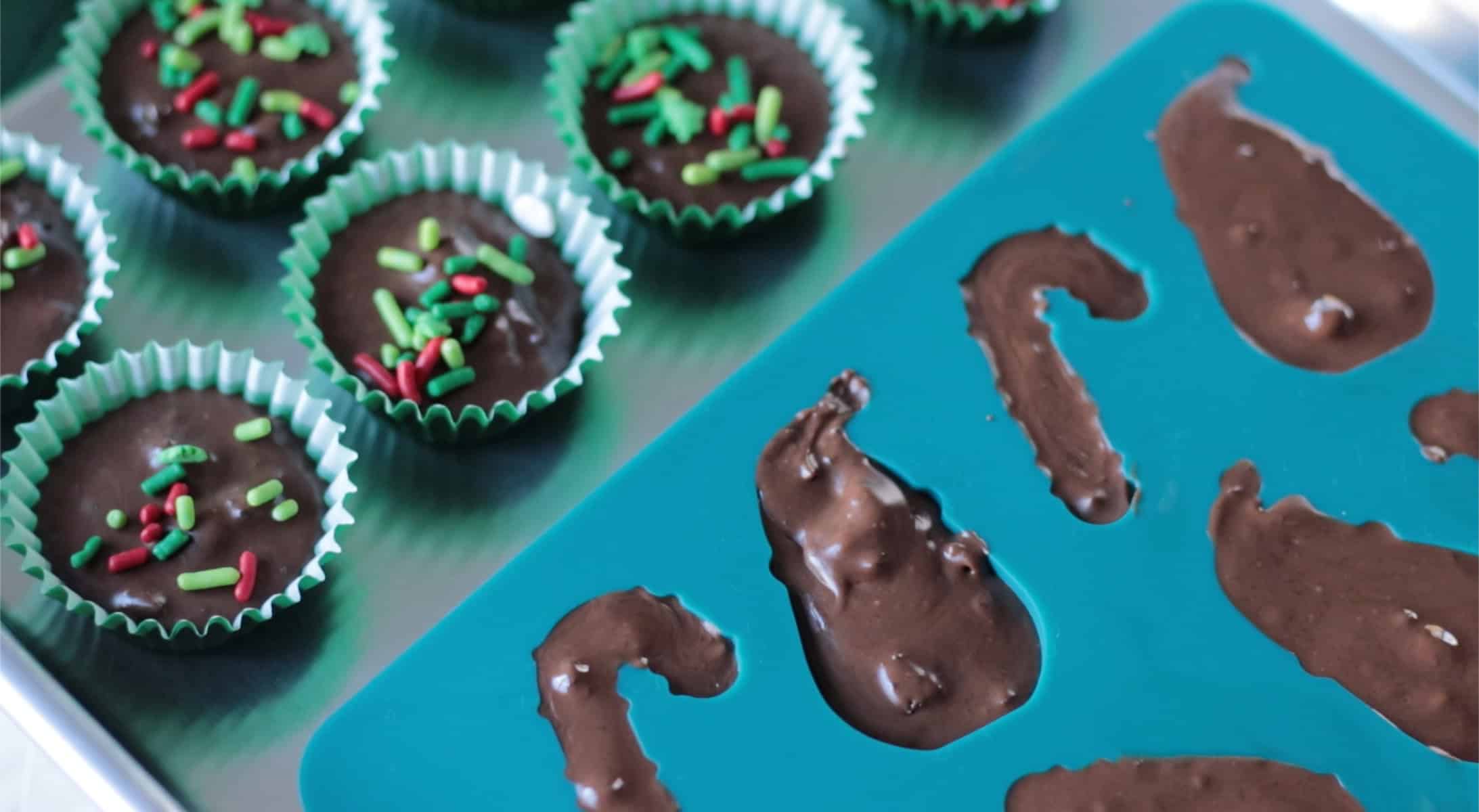 Blue silicone molds filled with melted chocolate and mini muffin cups with chocolate and sprinkles.