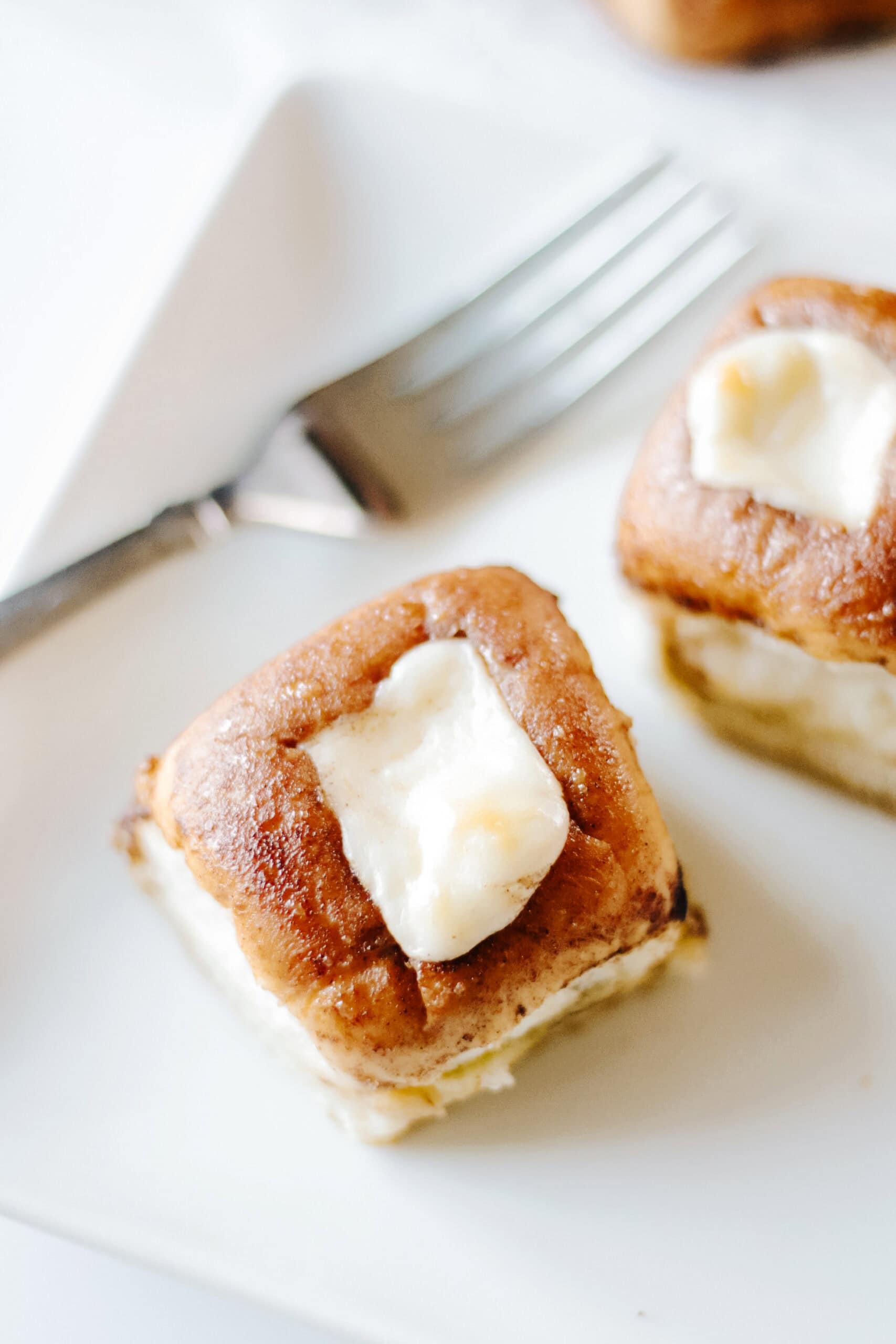 Hawaiian danish roll on a white plate with fork.