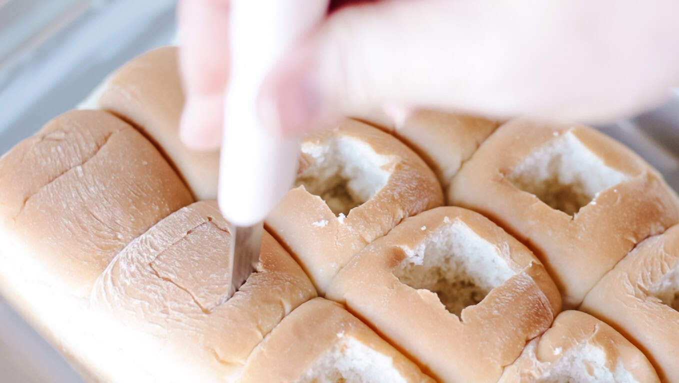 Knife cutting square out of the center of each roll.