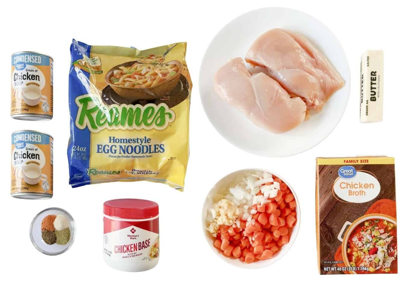 Two cans of cream of chicken soup, one bag of frozen noodles, bowl of spices, plate of chicken breasts, box of chicken broth, bowl of chopped onions and carrots, stick of butter and chicken base.