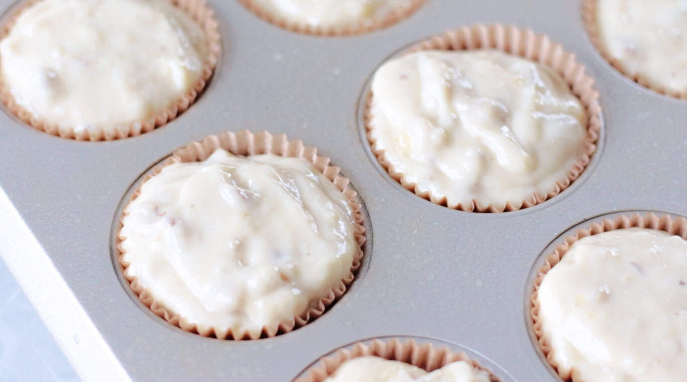 Muffin pan with liners and filled with batter.