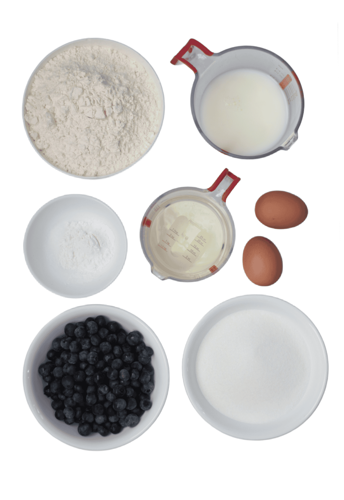 Bowls of flour, sugar, baking powder, salt, 2 eggs, cup of oil, cup of milk and bowl of blueberries.