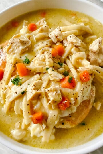 White bowl of chicken and noodles.