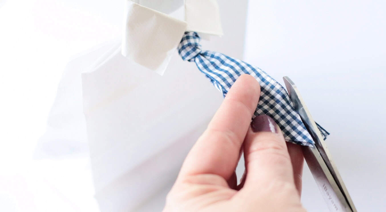 Scissors trimming the end of the ribbon.
