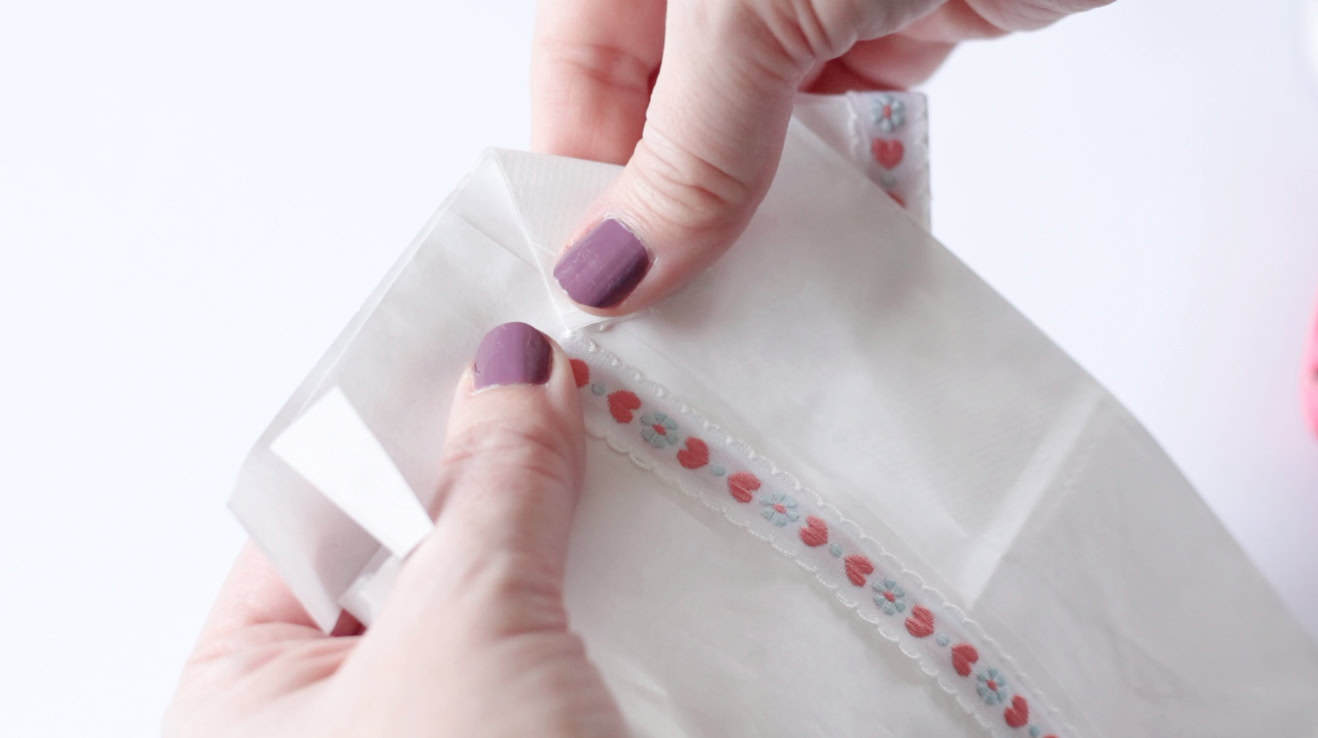 Hands folding the collar of the bag down.