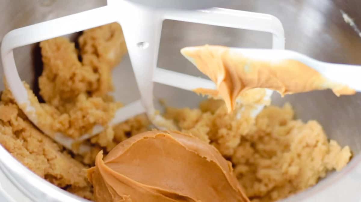 Metal mixing bowl of butter, sugar and peanut butter.