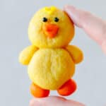 Hand holding yellow chick sugar cookie.