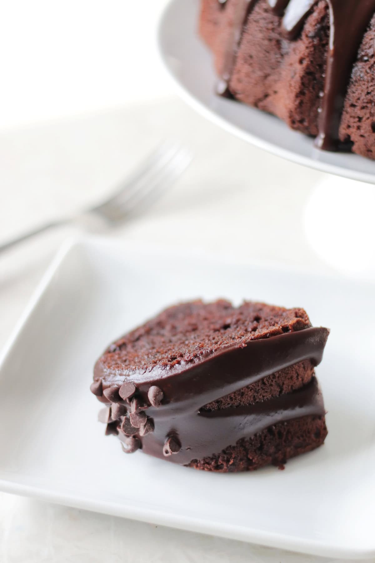 Slice of chocolate bundt cake on white plate.