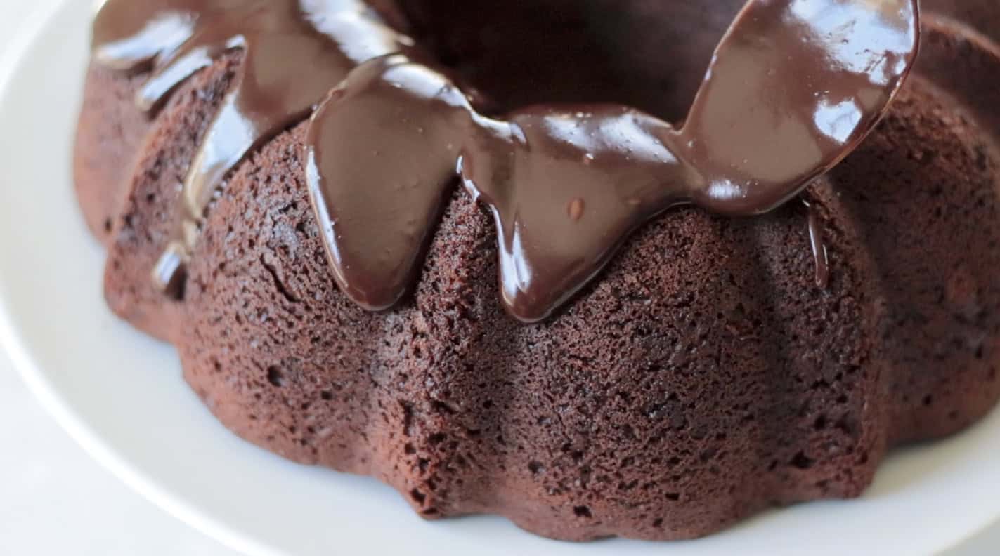 Ganache spooned over bundt cake.