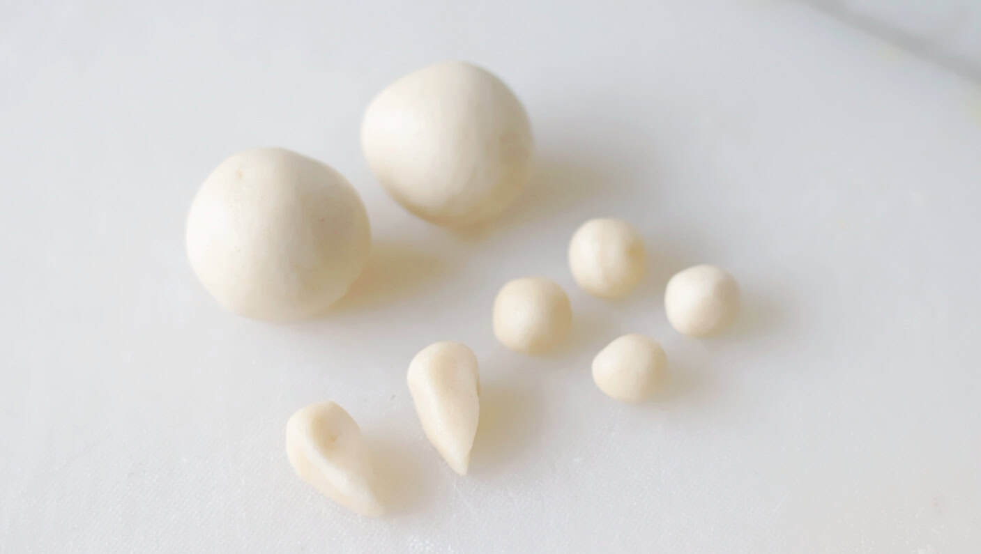 Two large balls of dough, 4 small balls of cookie dough and two ear shapes of dough.