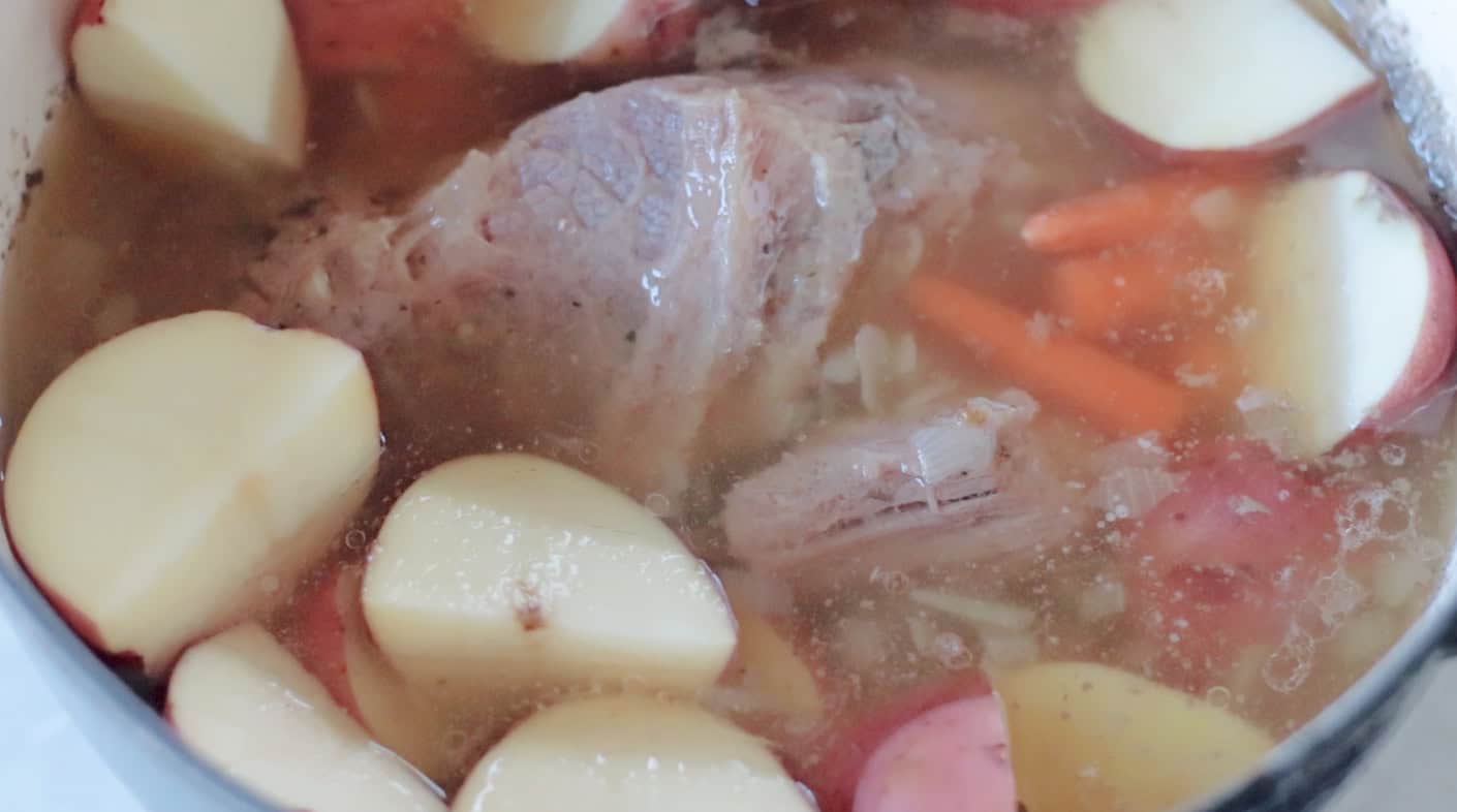 Corned beef, potatoes and carrots simmering in Dutch oven.