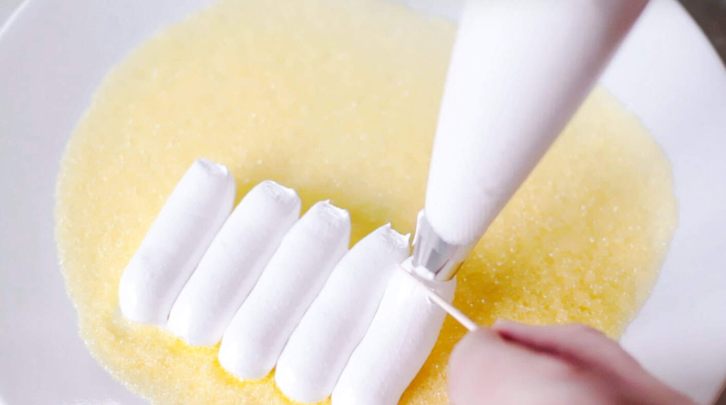 Marshmallow mixture piped into ovals.