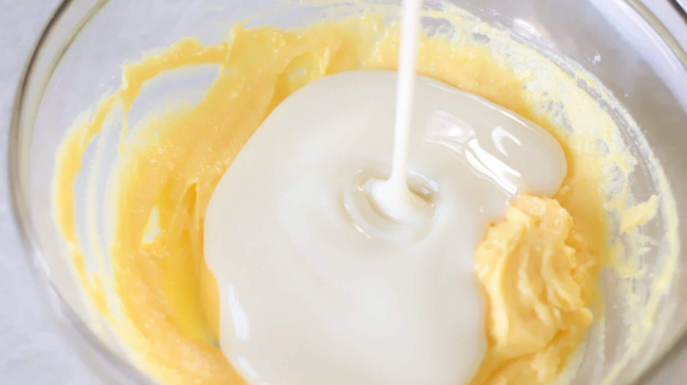 Sweetened condensed milk poured into mixing bowl with vanilla pudding.