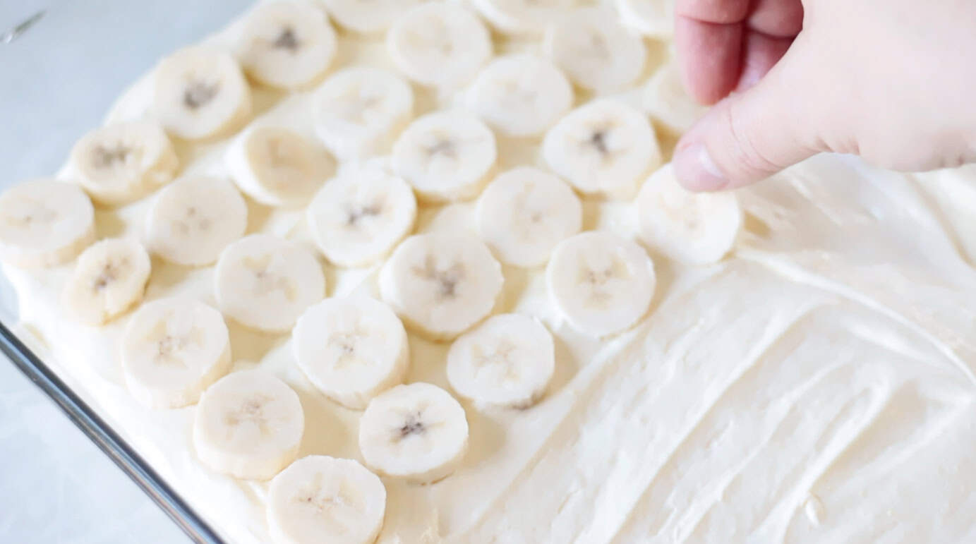 Sliced bananas on top of layer of vanilla pudding.