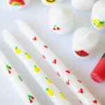 White candles decorated with wax candle pens.