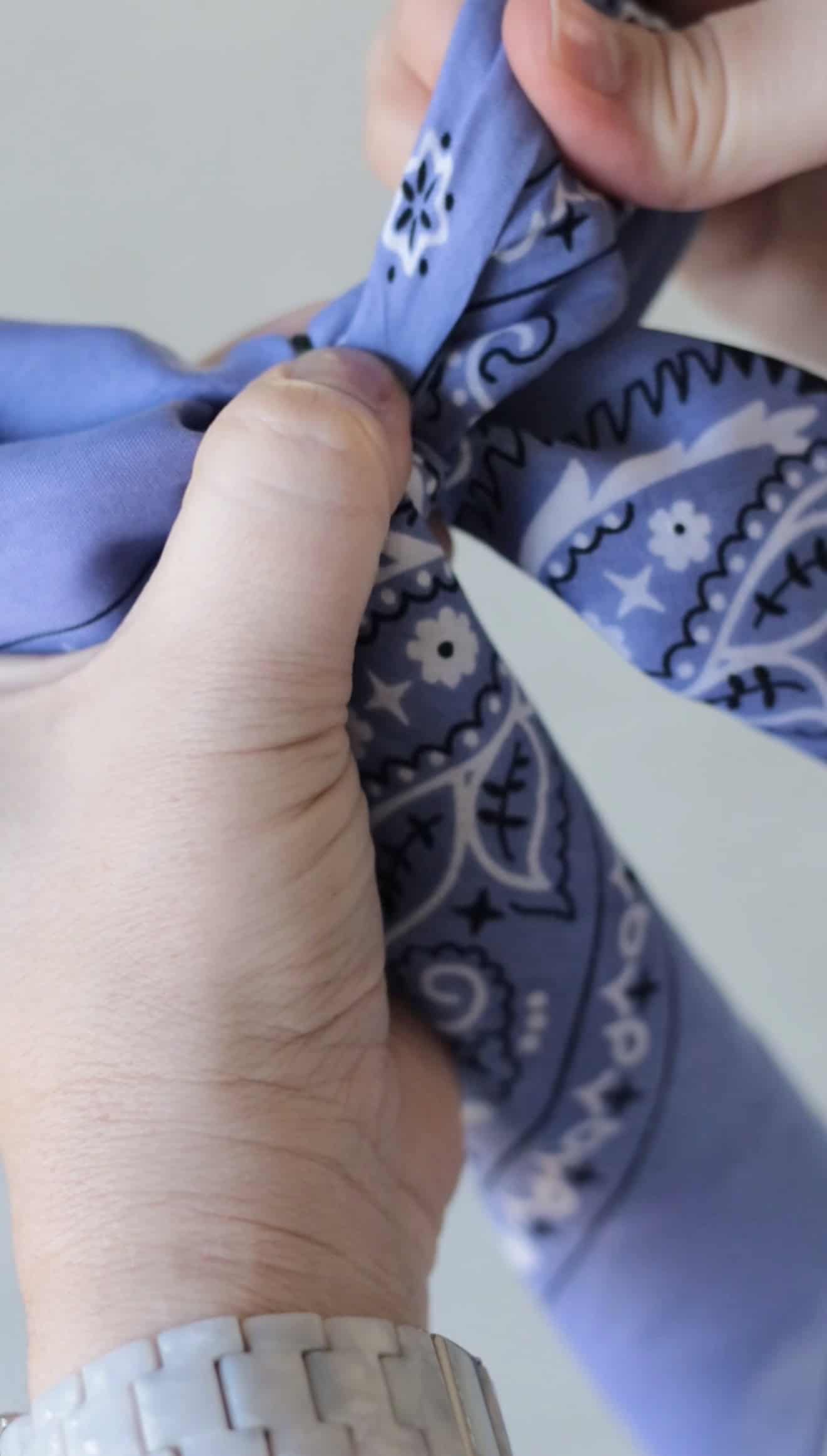 Hand holding a purple bandana hair bow.