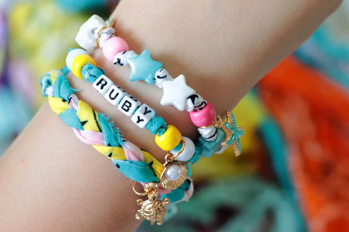 Arm wearing 3 bandana bead bracelets.