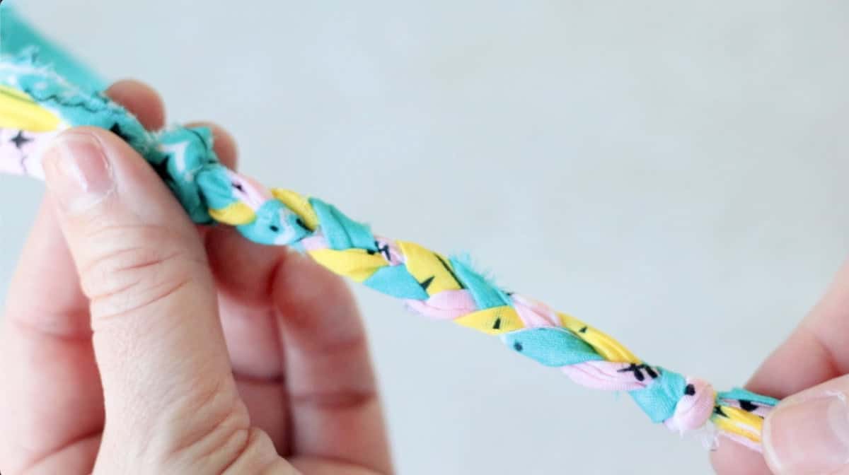 Hand holding braided bracelet.
