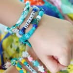 Arms with stacks of bandana bracelets on them.