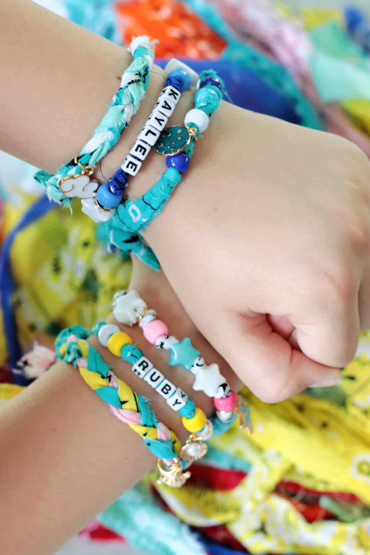 Hands with stacks of bandana bracelets on each.