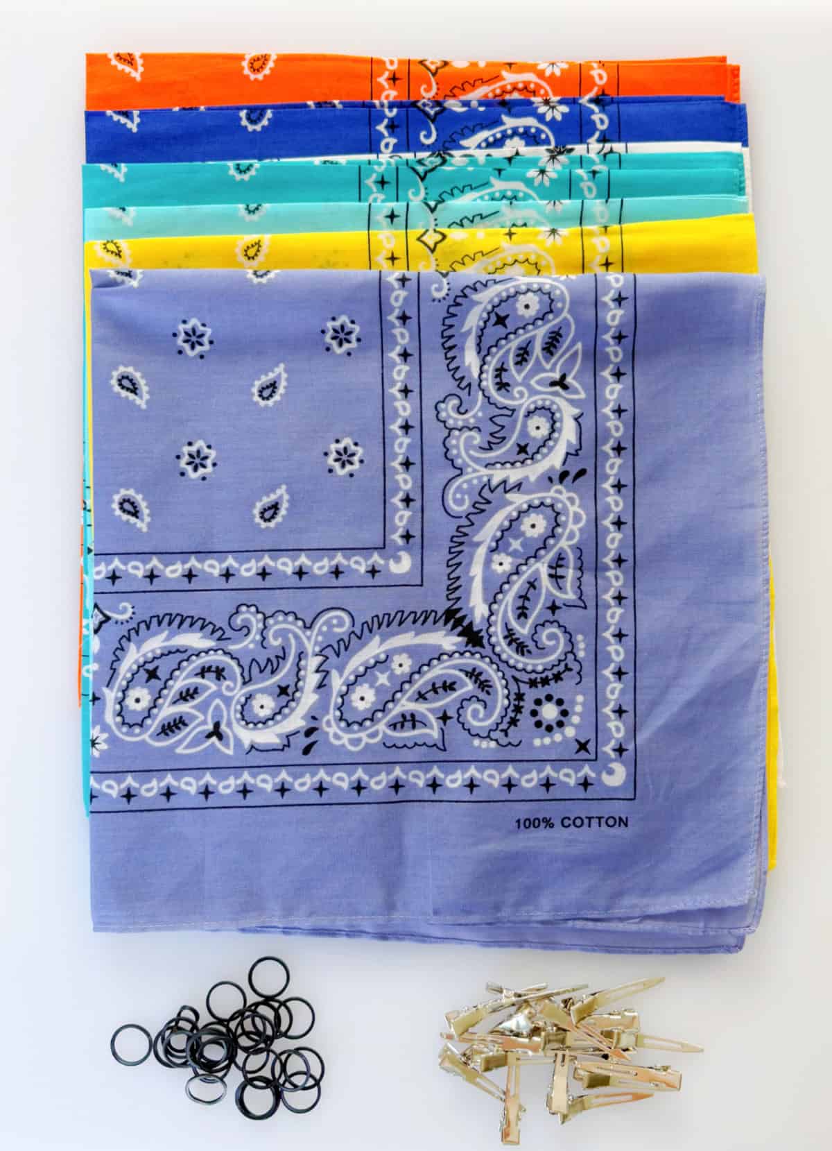 Stack of folded bandanas, hair ties and hair clips.