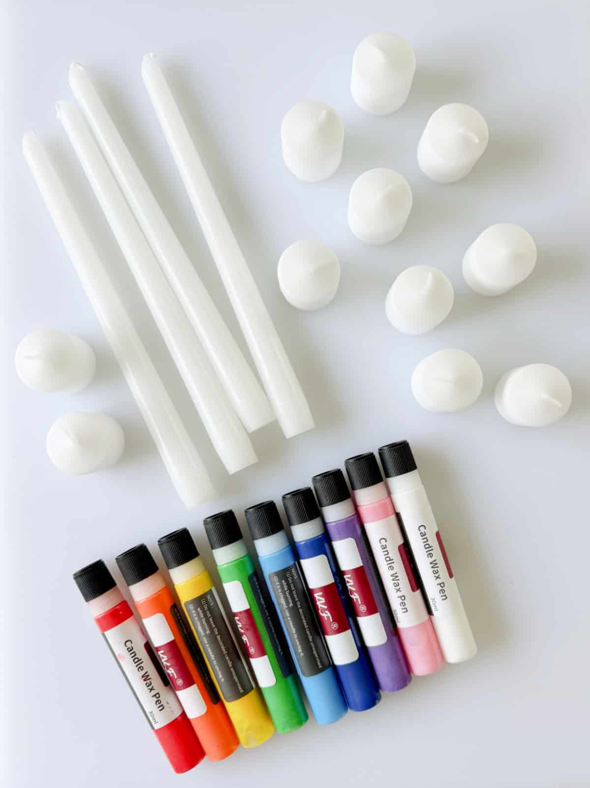 Colored wax candle pens with plain white candles.