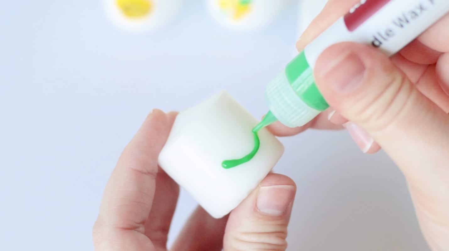 Votive candle decorated with green wax pen.
