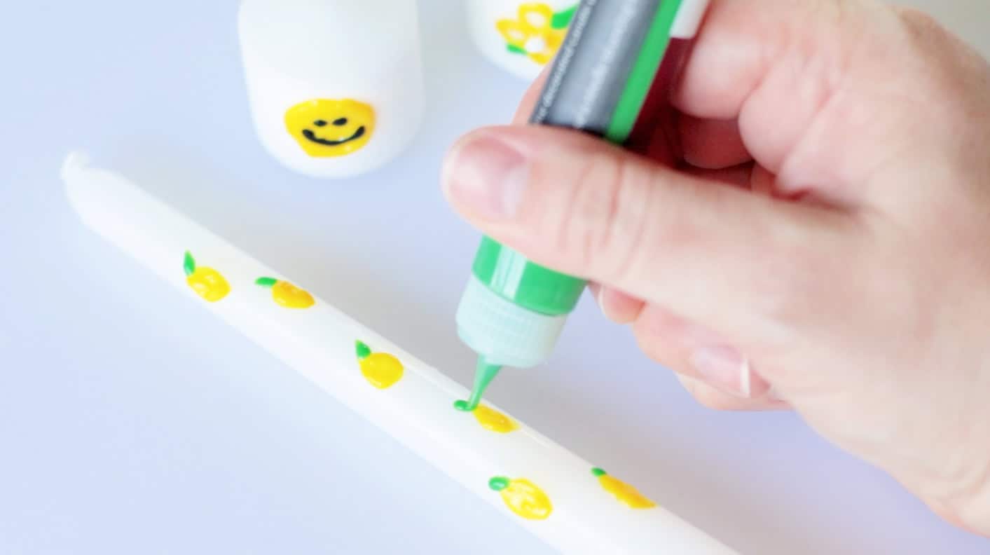 Candle wax pens decorating a white tape candle.
