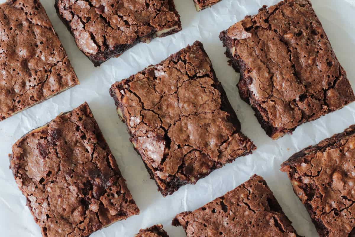 Brownie cut into squares on parchment paper.