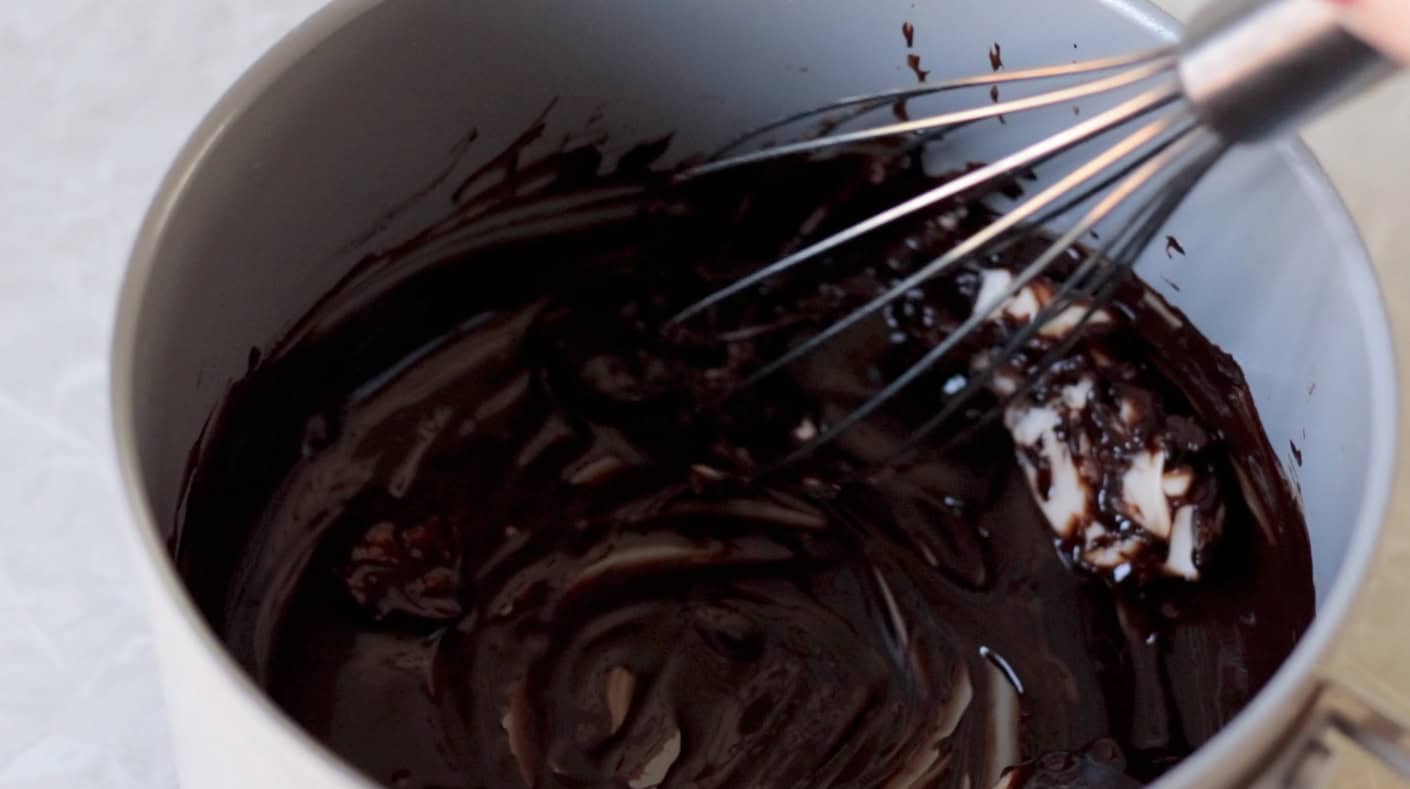 Whisk mixing butter and melted chocolate in pan.
