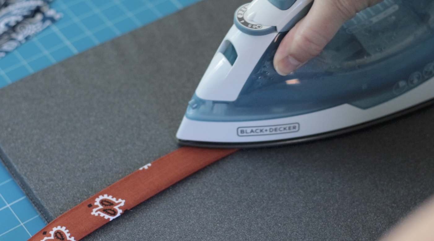 Iron pressing strip of fabric.