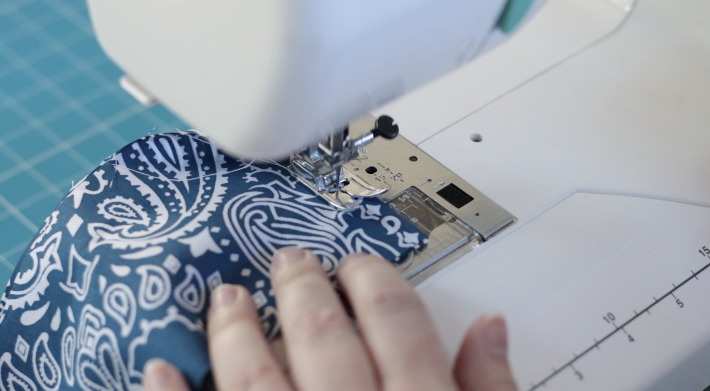 Sewing machine sewing two pieces of handle fabric together.