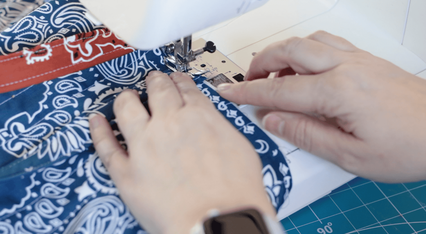 Sewing machine stitching handles to bag.