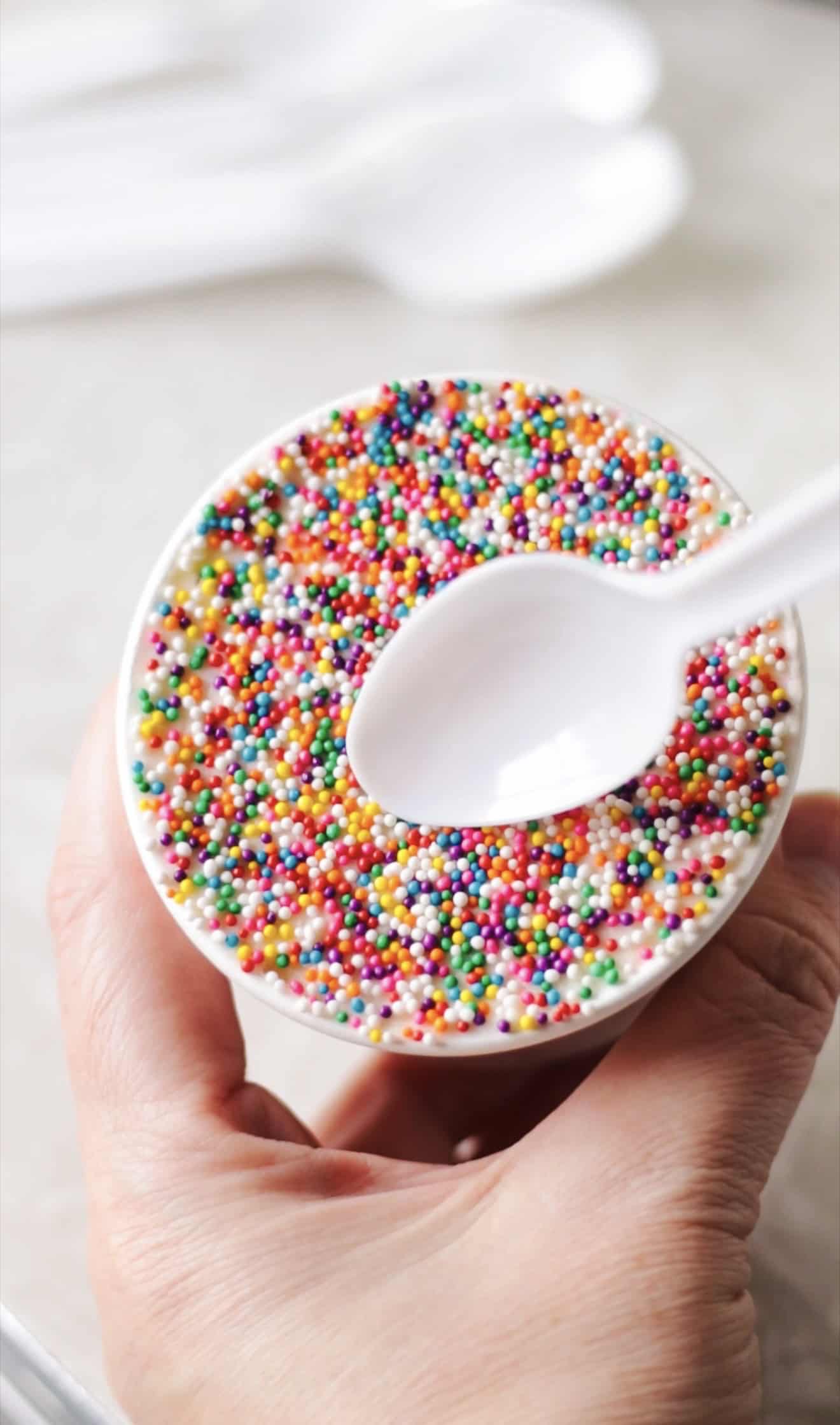 Plastic spoon gliding over top of dot cake.