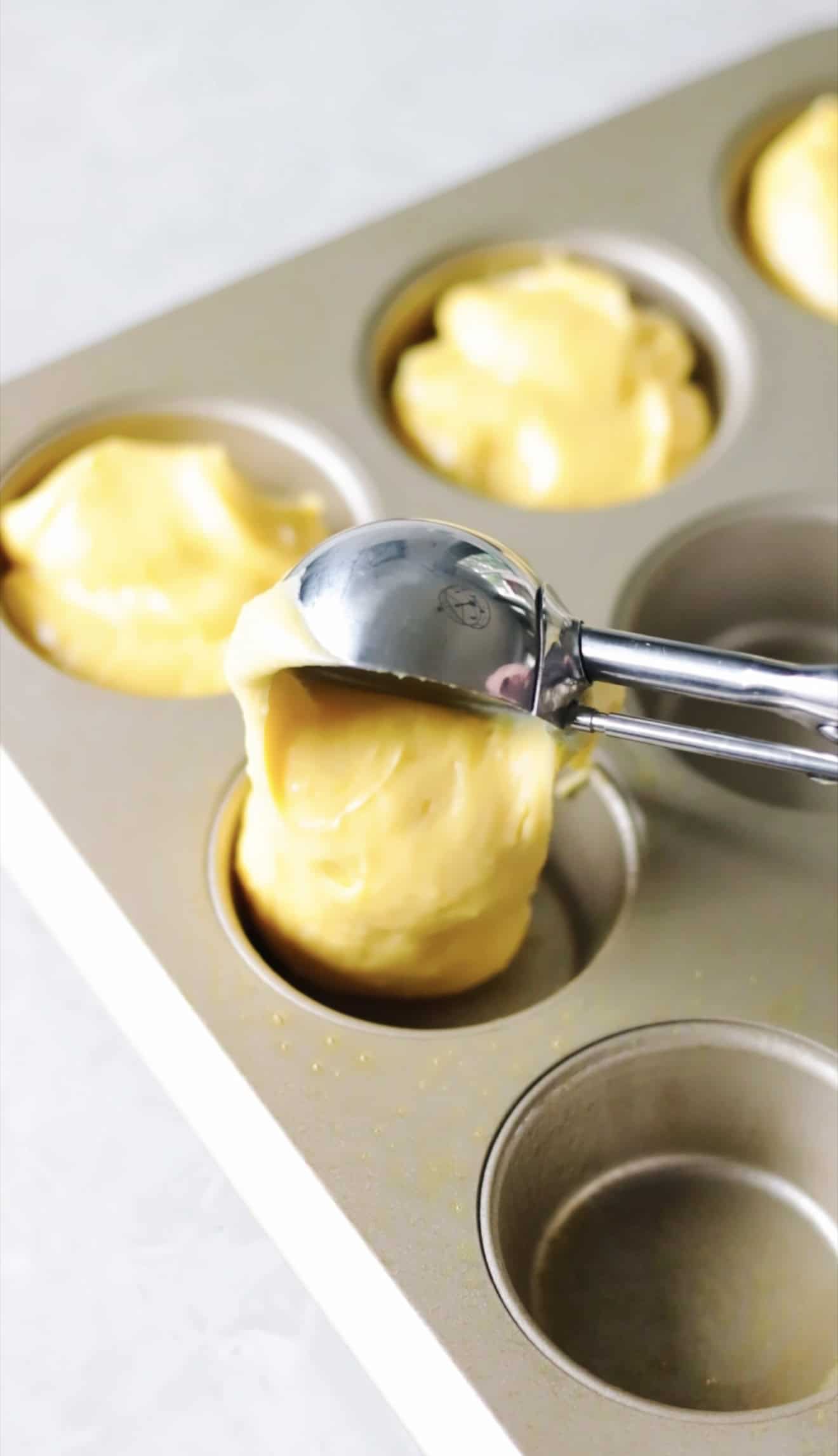 Cupcake pan with cake batter scoops.