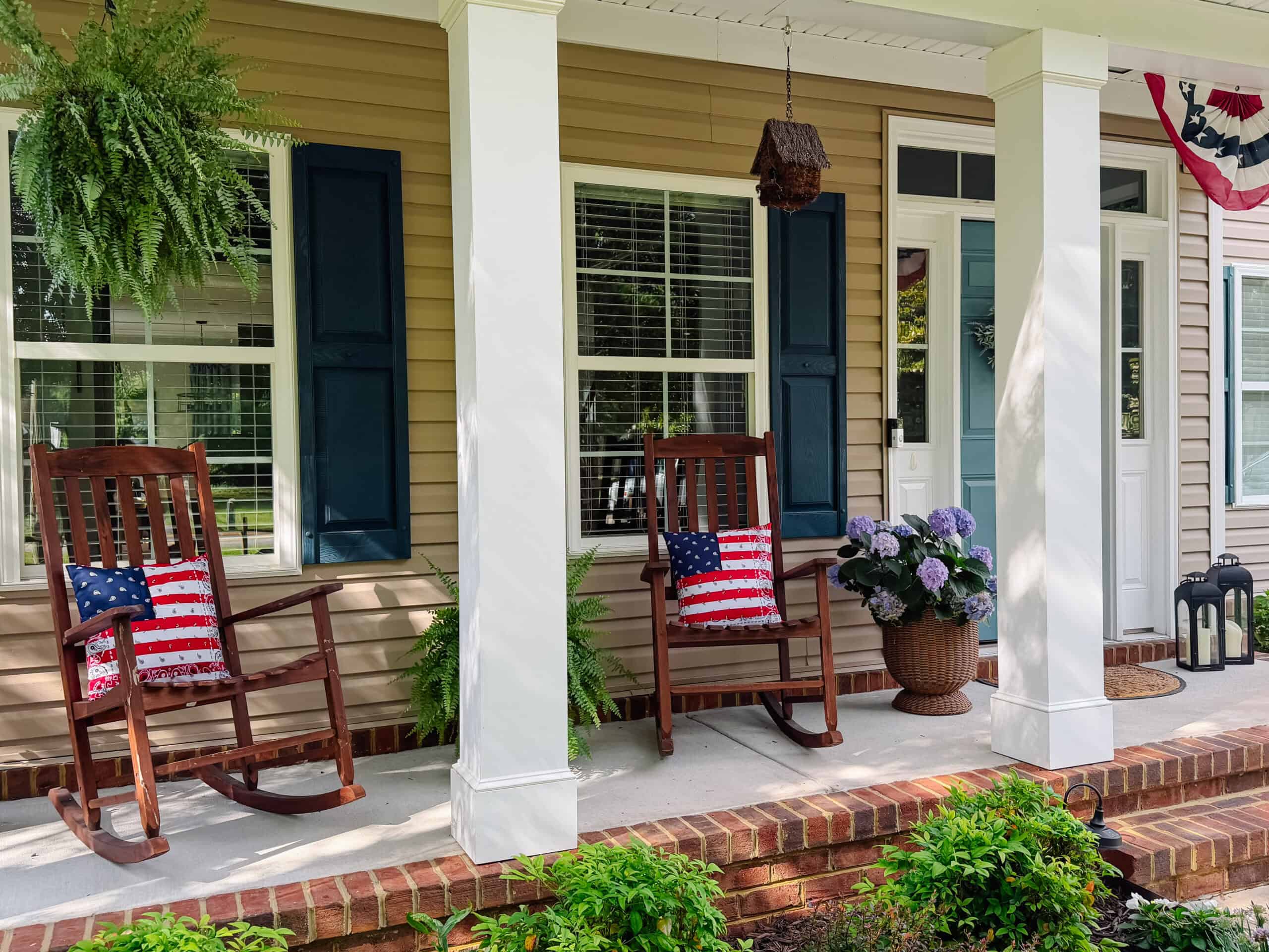 Rocking chairs on porch with patriotic pillows.